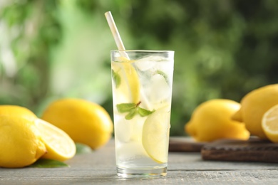 Photo of Cool freshly made lemonade and fruits on grey wooden table