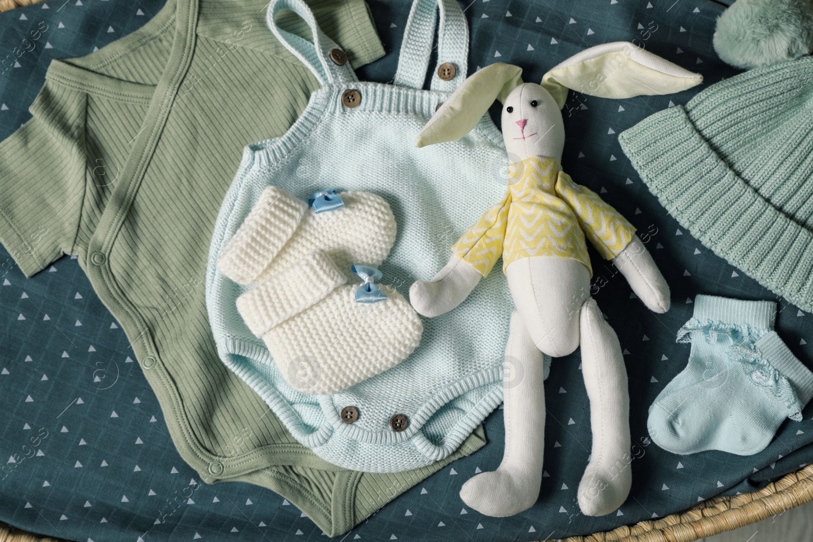 Photo of Baby clothes and accessories on blue fabric, flat lay