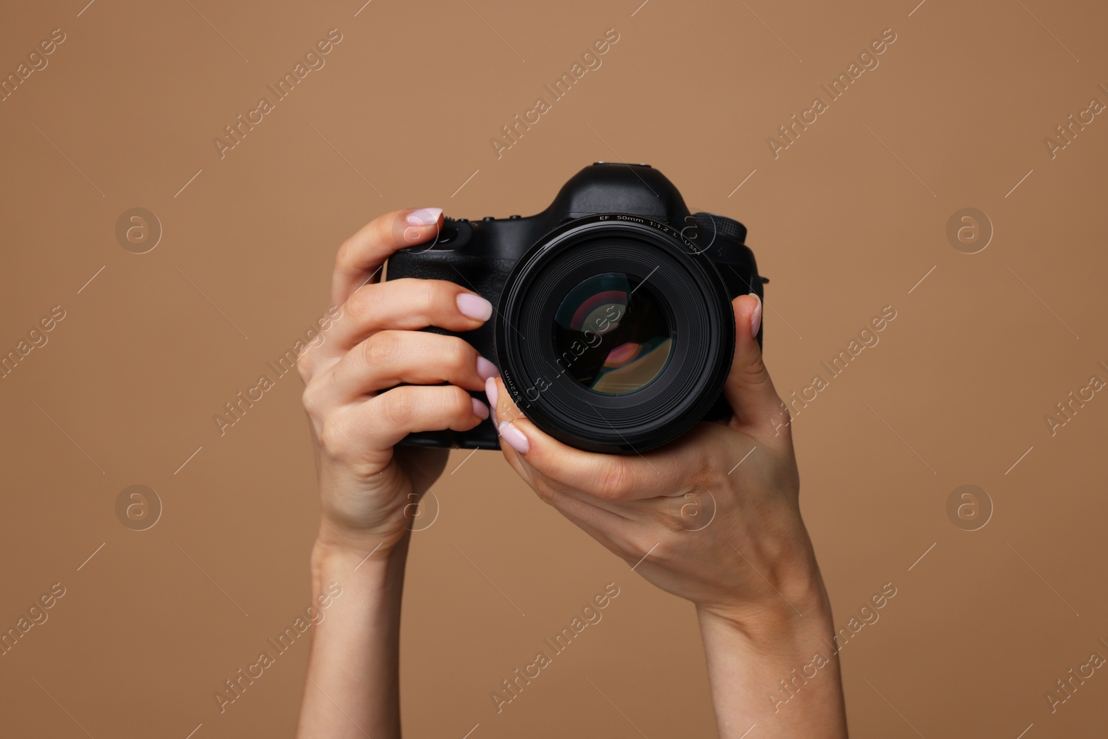 Photo of Photographer with camera on brown background, closeup