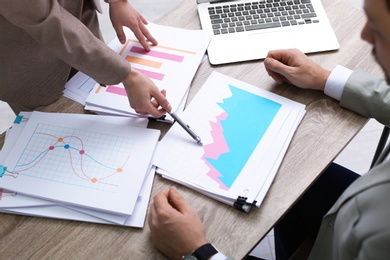 Photo of Office employees working with documents at table, closeup