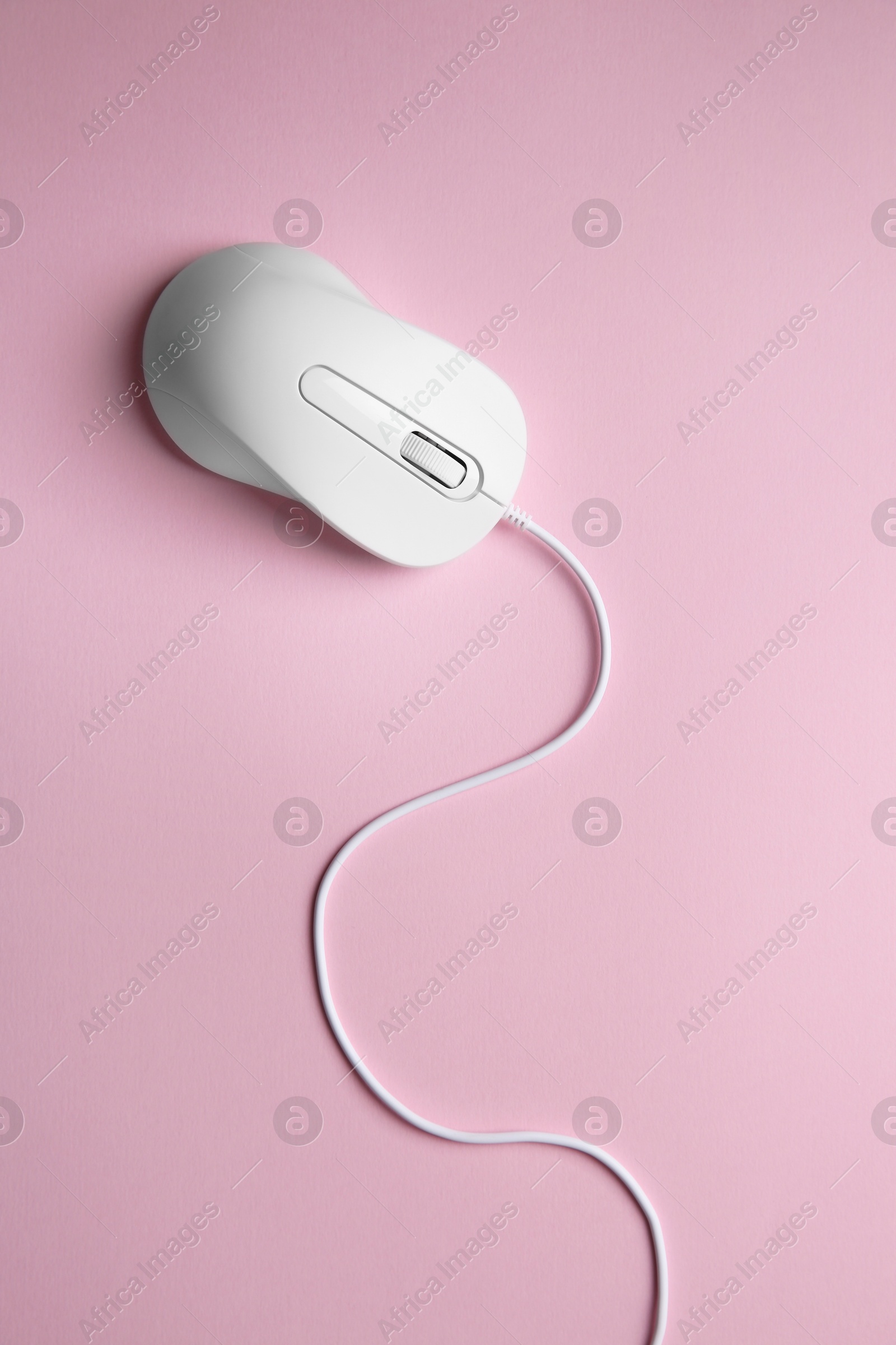 Photo of One wired mouse on pink background, top view