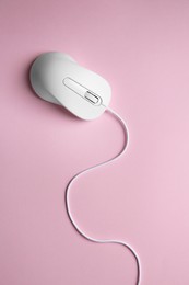 One wired mouse on pink background, top view