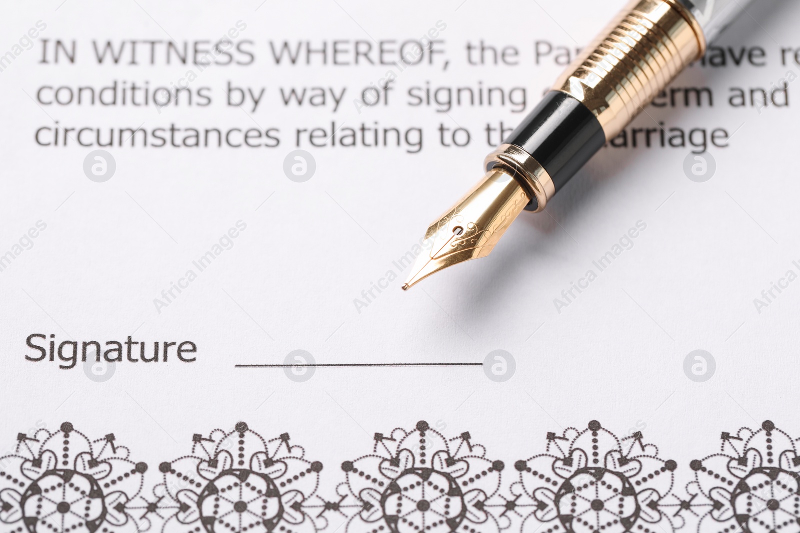 Photo of Marriage contract and pen on table, closeup