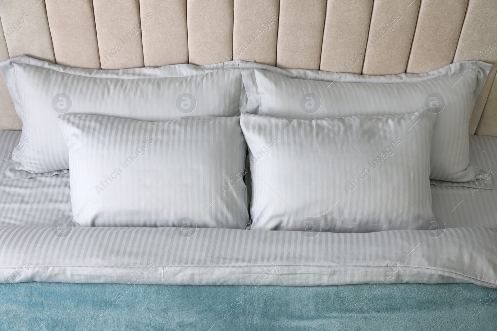 Photo of Comfortable bed with soft blanket and pillows, above view