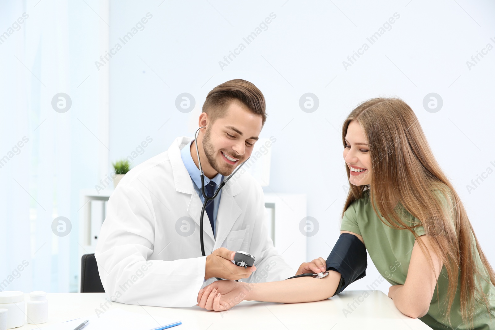 Photo of Doctor checking young woman's pulse in hospital