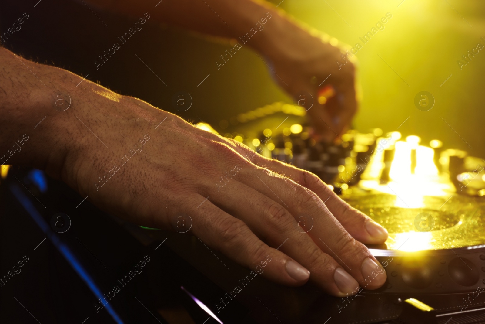 Photo of DJ creating music on modern console mixer in night club, closeup