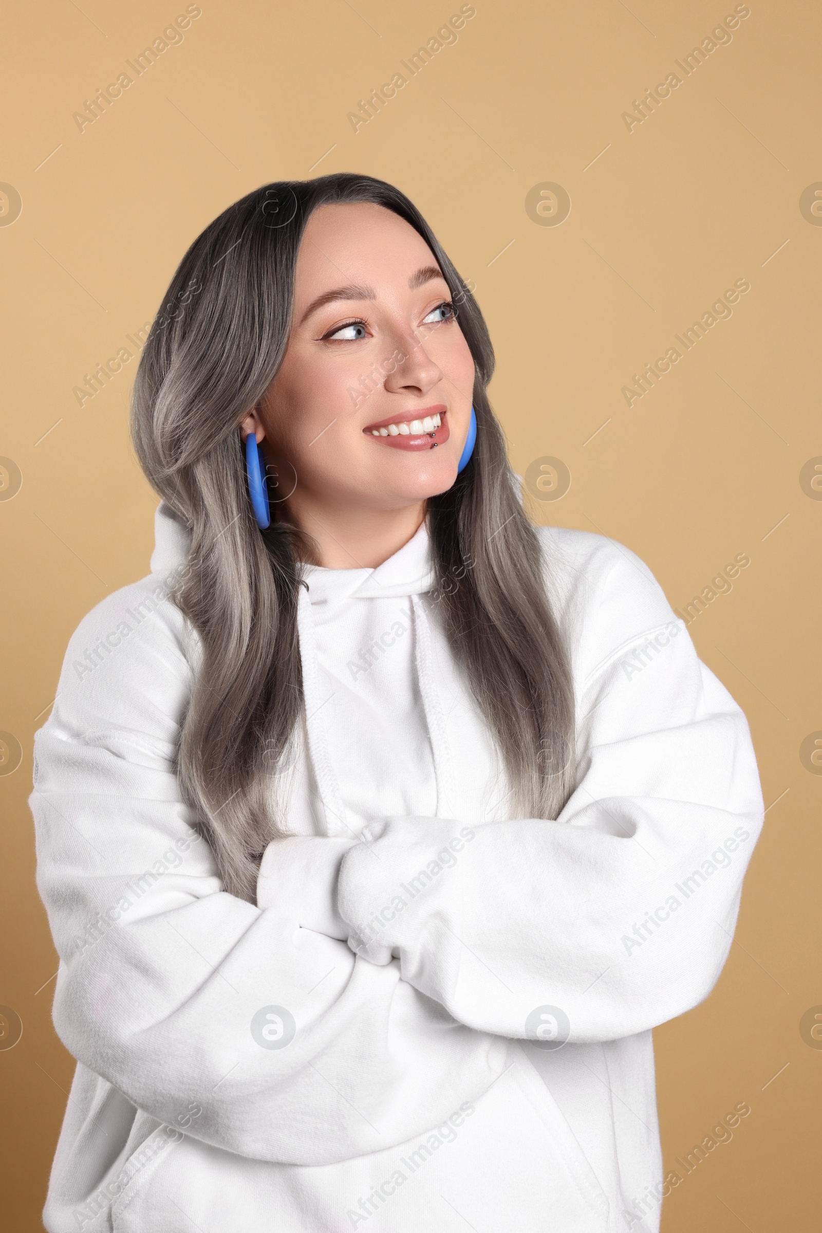 Image of Smiling woman with ash hair color on beige background