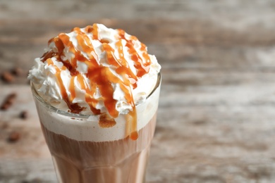 Photo of Glass of coffee with caramel topping on table, closeup