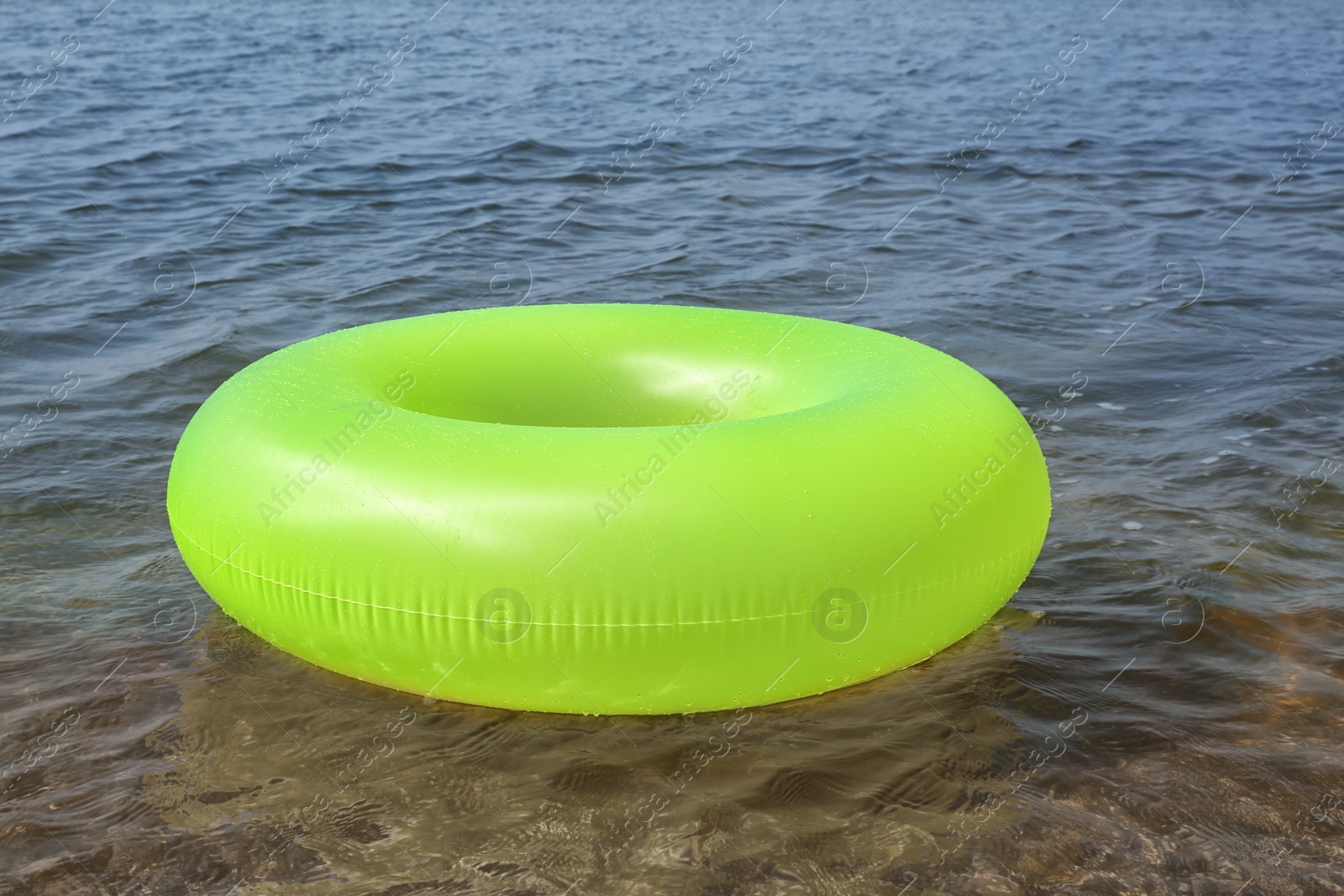 Photo of Bright inflatable ring floating on sea water. Summer vacation