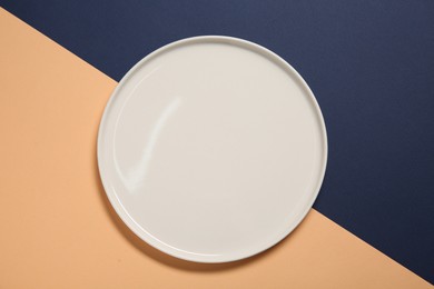 Photo of One white plate on color background, top view