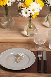 Photo of Elegant festive setting with floral decor on wooden table