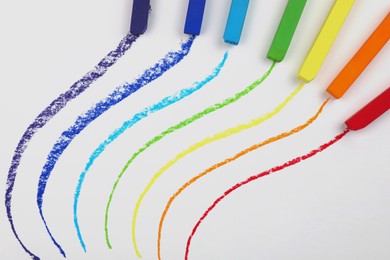 Photo of Colorful pastel chalks and lines on white background, flat lay. Drawing materials