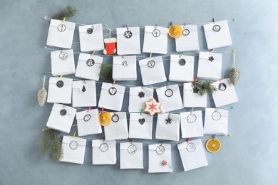 Photo of Advent calendar with gifts and Christmas decor hanging on grey wall