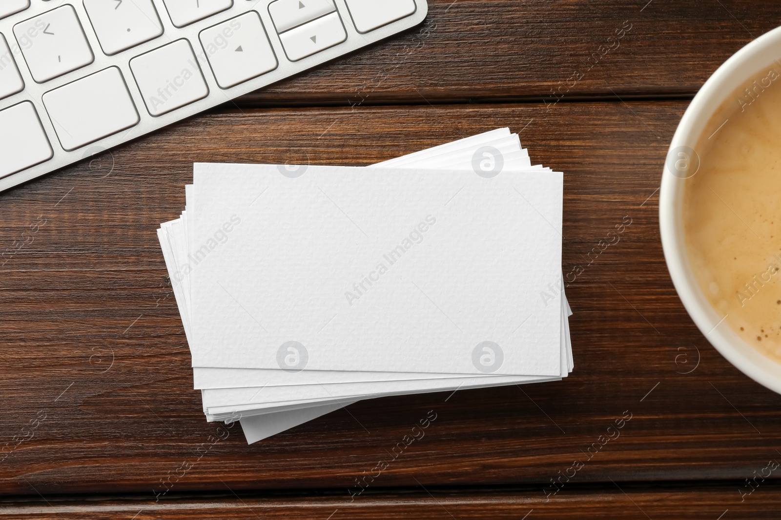 Photo of Blank business cards, coffee and keyboard on wooden table, flat lay. Mockup for design