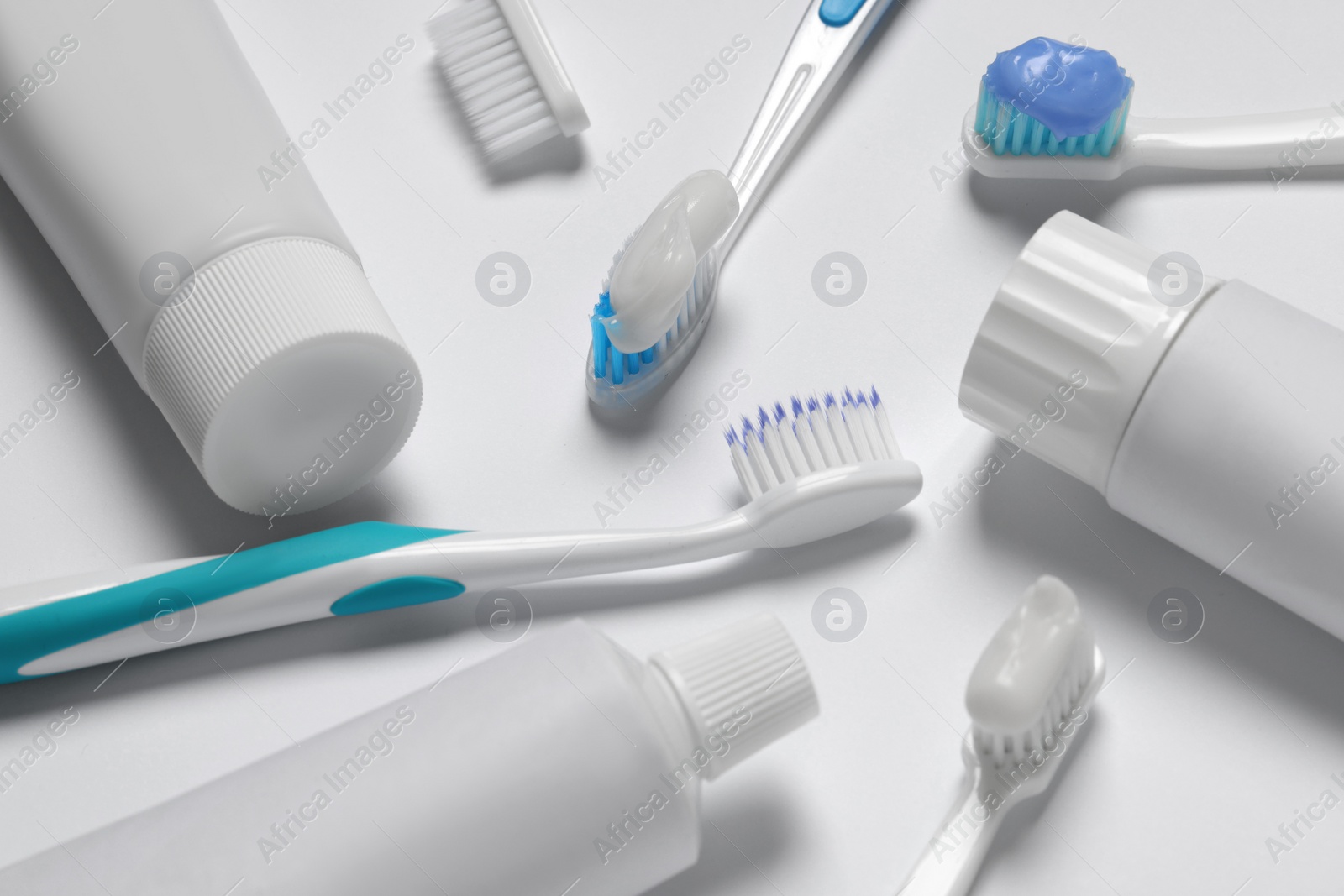 Photo of Composition with plastic toothbrushes and paste on white background