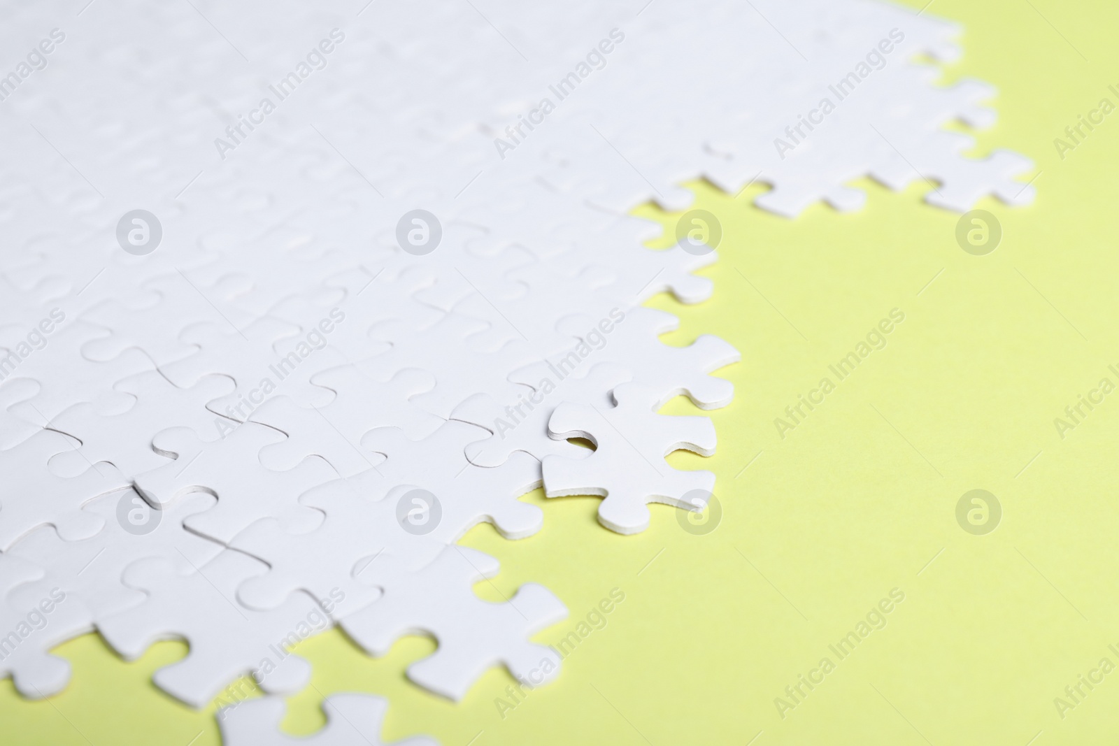 Photo of Blank white puzzle pieces on yellow background