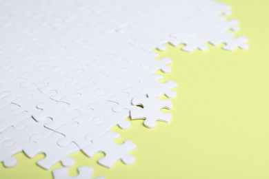Photo of Blank white puzzle pieces on yellow background