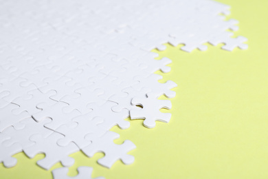 Blank white puzzle pieces on yellow background