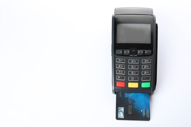 Photo of Modern payment terminal with credit card on white background, top view