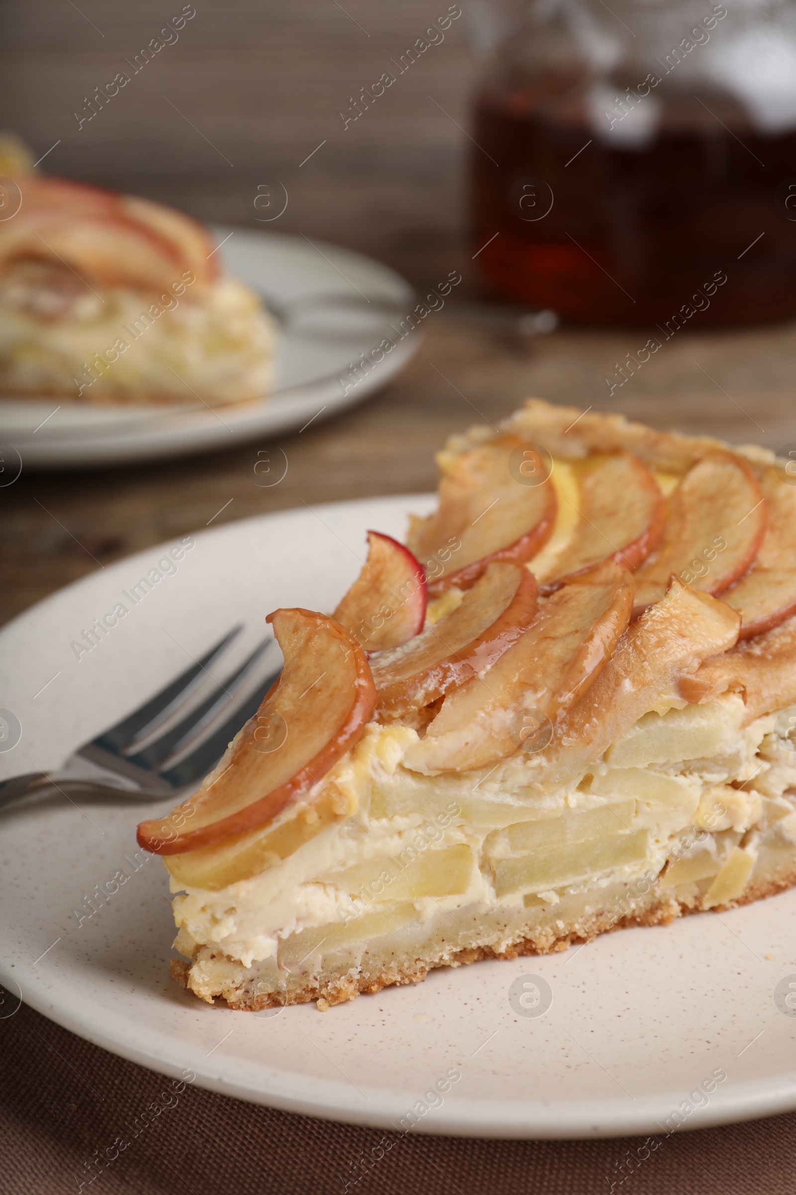 Photo of Piece of delicious homemade apple pie on wooden table, closeup