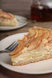 Piece of delicious homemade apple pie on wooden table, closeup