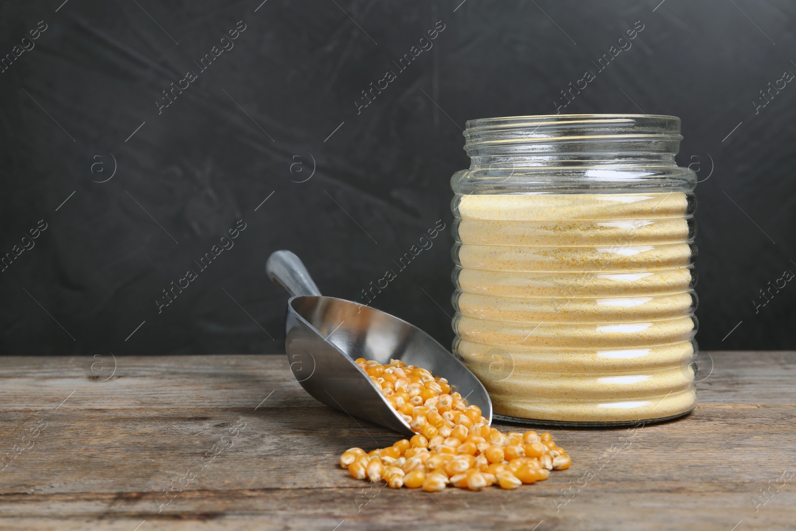 Photo of Bowl with corn flour and kernels on table. Space for text