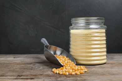 Photo of Bowl with corn flour and kernels on table. Space for text