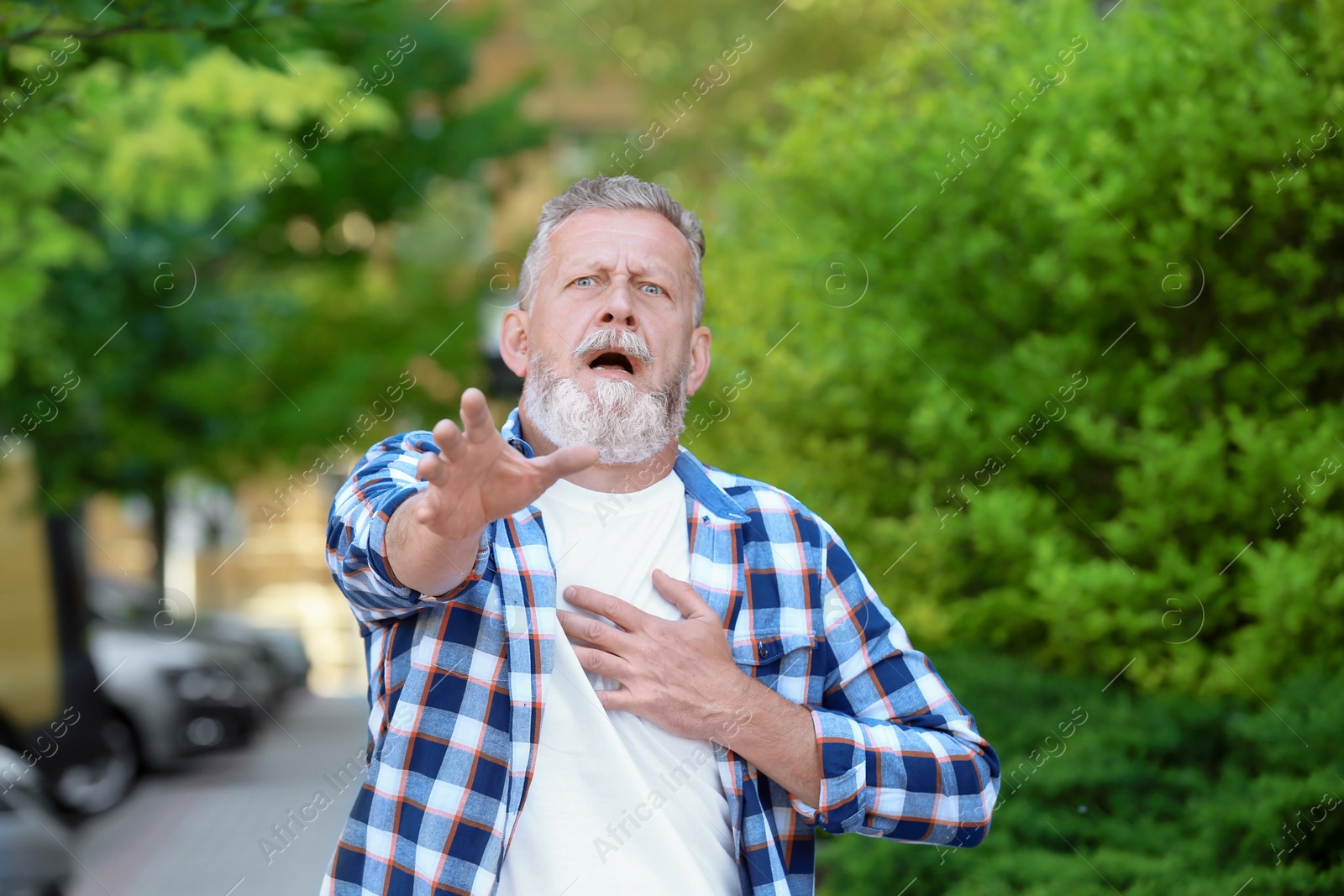 Photo of Mature man having heart attack, outdoors