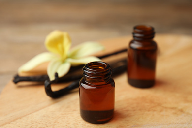 Photo of Aromatic homemade vanilla extract on wooden table, closeup