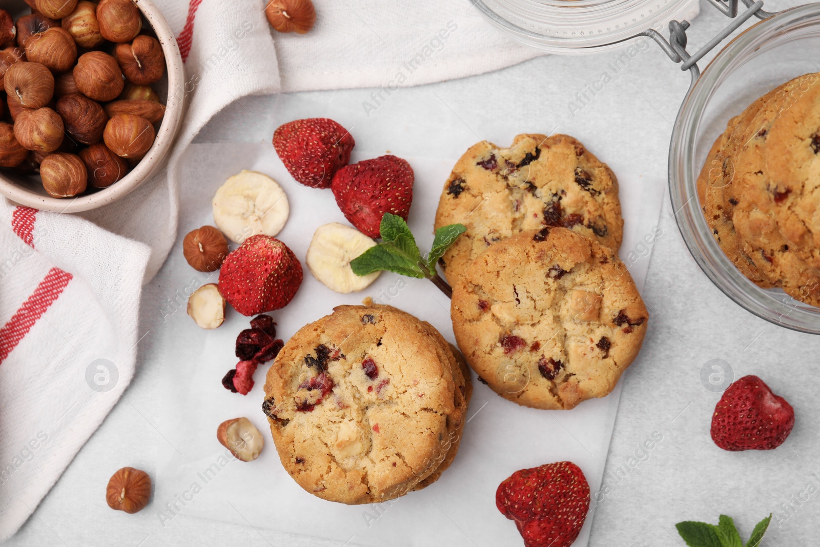Cookies with freeze dried fruits, nuts and mint on white table, flat lay Photo of Cookies with freeze dried fruits, nuts and mint on white table, flat lay