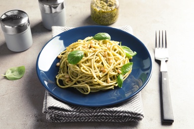 Plate of delicious basil pesto pasta served for dinner on table