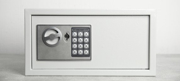 Steel safe with electronic lock on white background, banner design