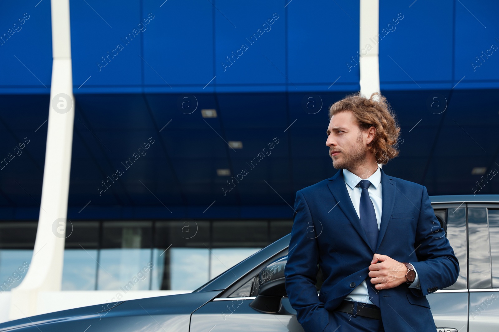 Photo of Attractive young man near luxury car outdoors