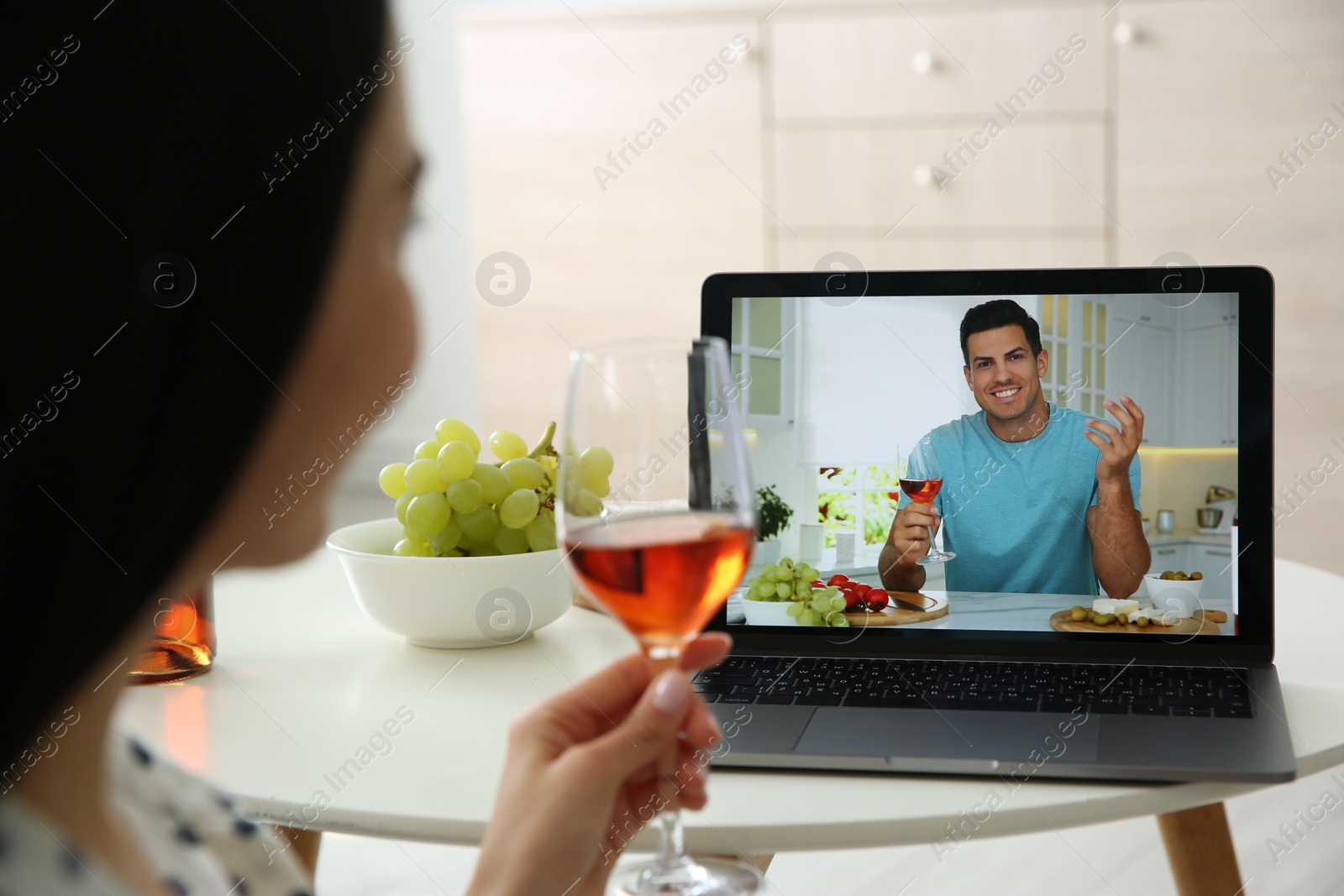 Photo of Friends drinking wine while communicating through online video conference at home. Social distancing during coronavirus pandemic