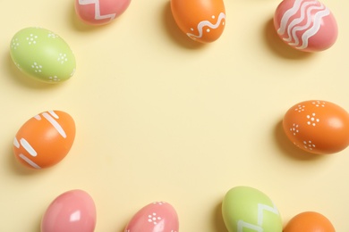 Photo of Flat lay composition of painted Easter eggs on color background, space for text