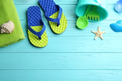 Photo of Flat lay composition with bright beach toys on color wooden background. Space for text