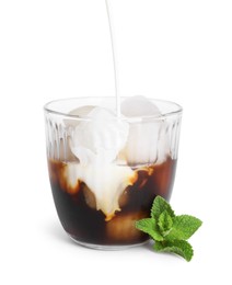 Photo of Pouring milk into glass of iced coffee on white background