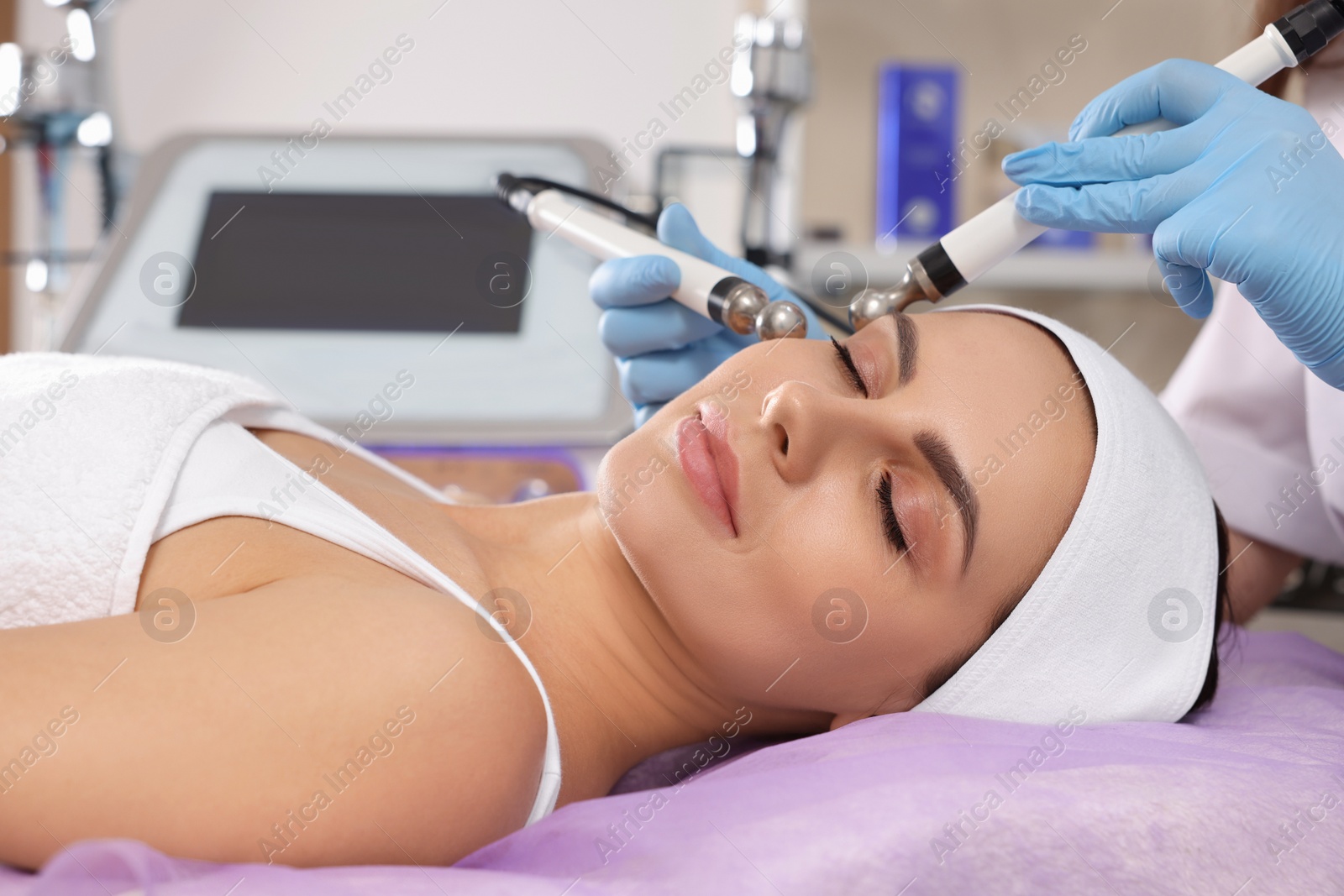 Photo of Young woman undergoing cosmetic procedure in beauty salon. Microcurrent therapy