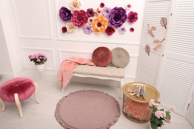 Elegant Easter photo zone with paper flowers and bench indoors, above view