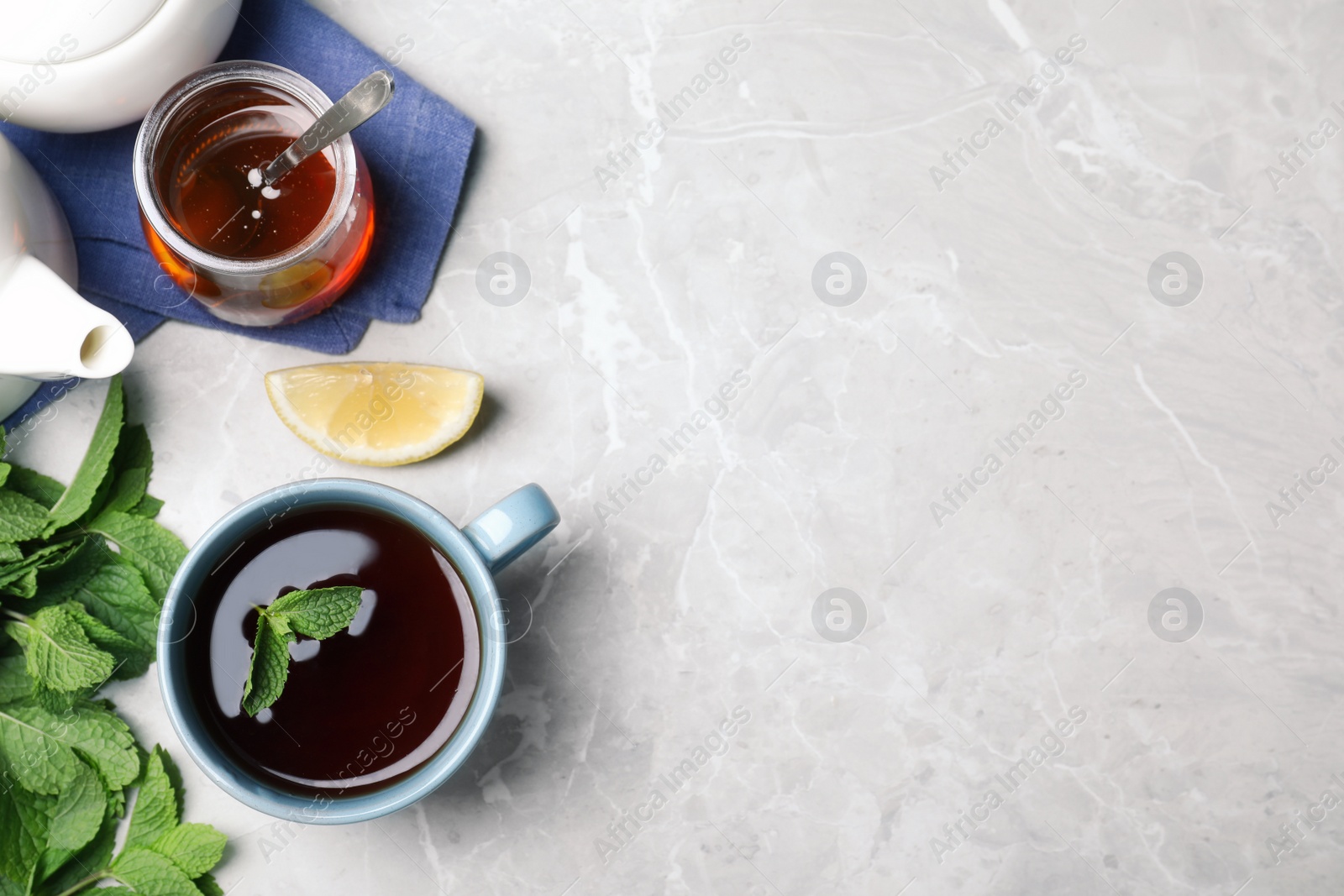 Photo of Fresh tea with mint, honey and lemon on light table, flat lay. Space for text