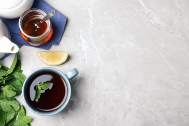 Photo of Fresh tea with mint, honey and lemon on light table, flat lay. Space for text