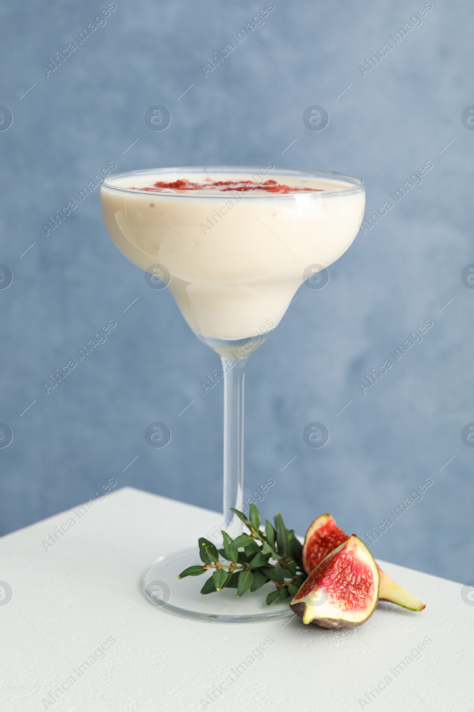 Photo of Delicious fig smoothie in glass on white table