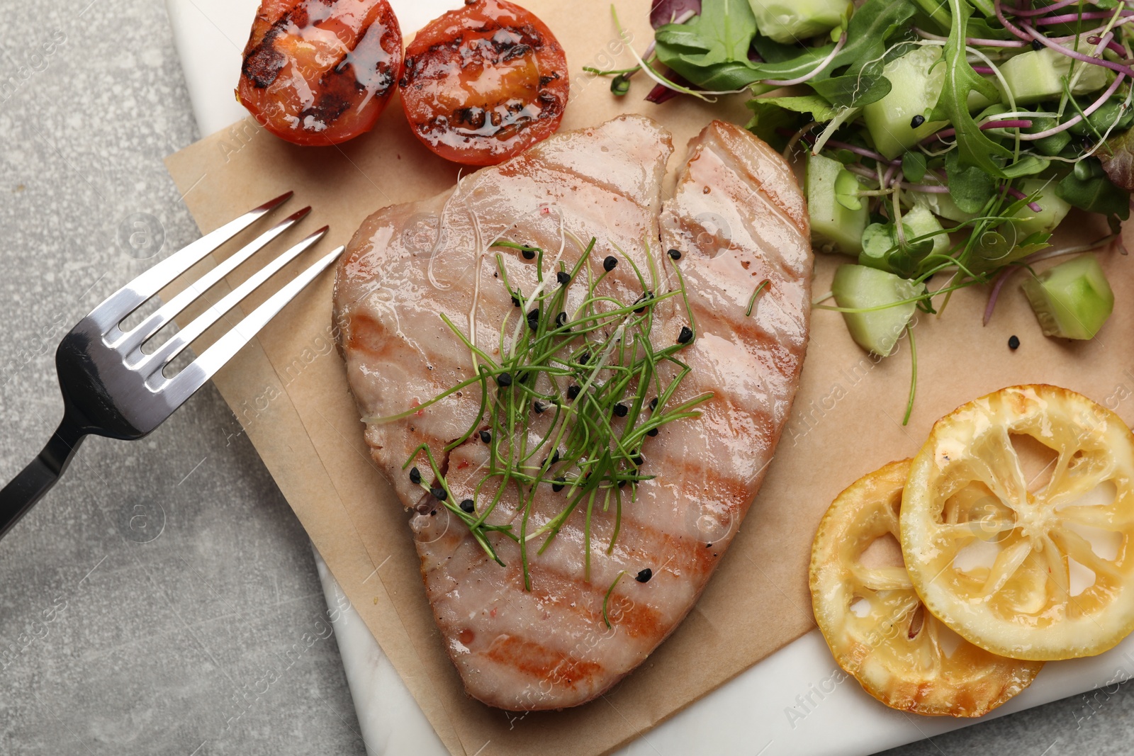 Photo of Delicious tuna steak served on light grey table, top view