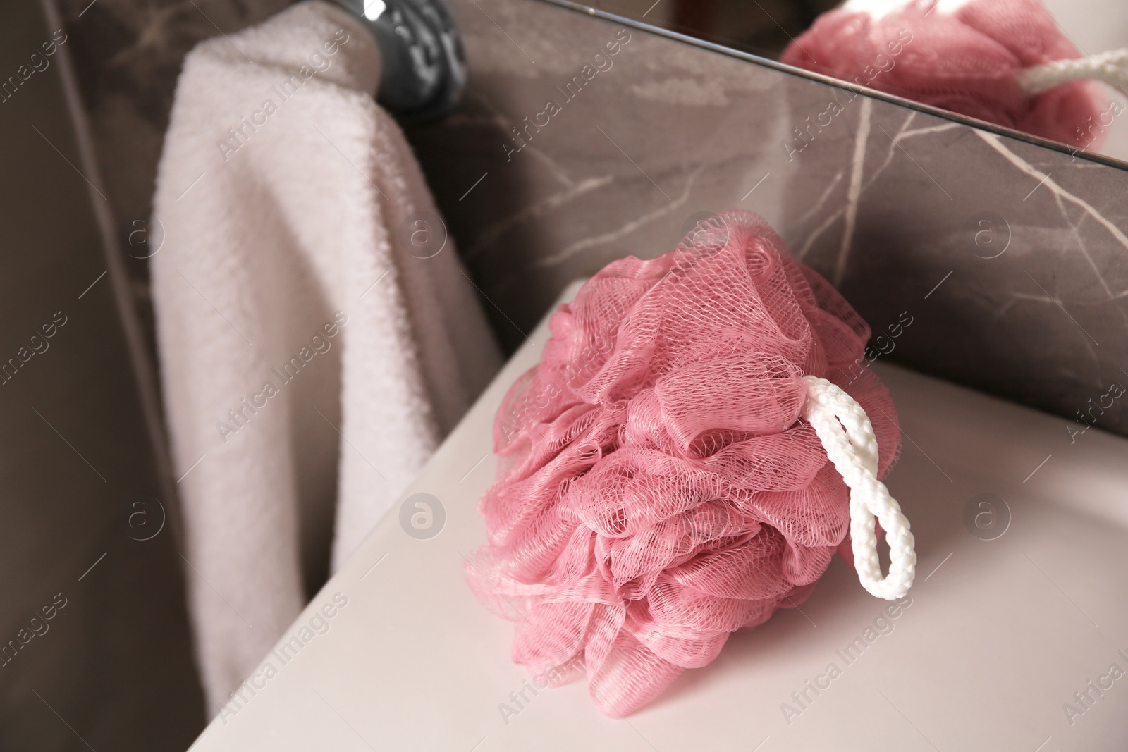 Photo of Pink shower puff on washbasin in bathroom