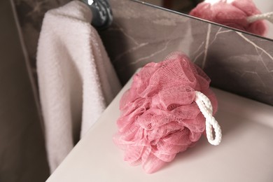 Pink shower puff on washbasin in bathroom