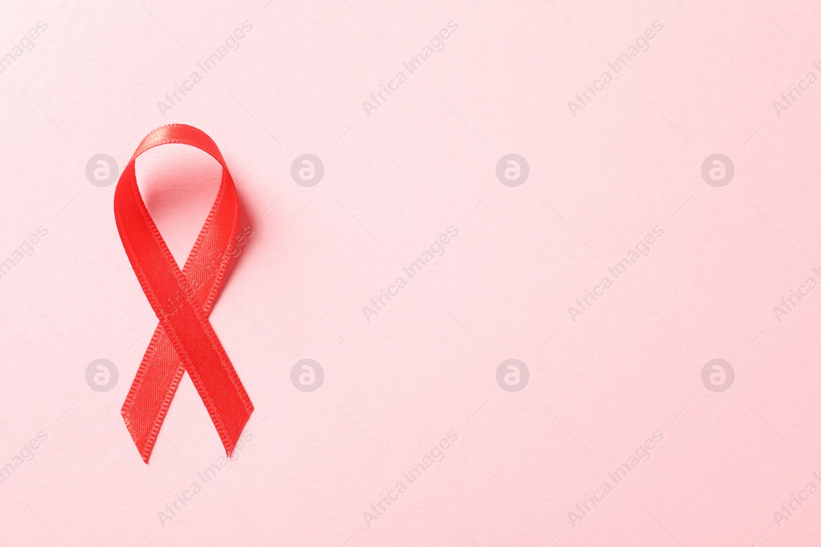 Photo of Red ribbon on color background, top view. Cancer awareness