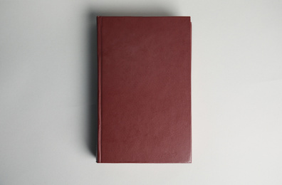 Hardcover book on light grey background, top view. Space for design