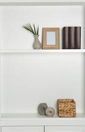 Photo of White shelving unit with different decor elements. Interior design