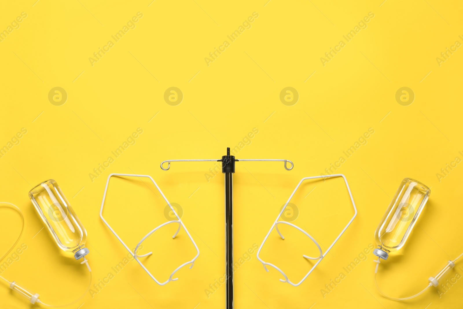Photo of IV infusion set on yellow background, flat lay. Space for text