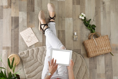 Photo of Woman with tablet sitting on floor, top view. Fashion blogger